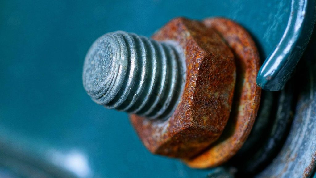 A completely rust nut is attached to a non-rust bolt as an example of galvanic corrosion.