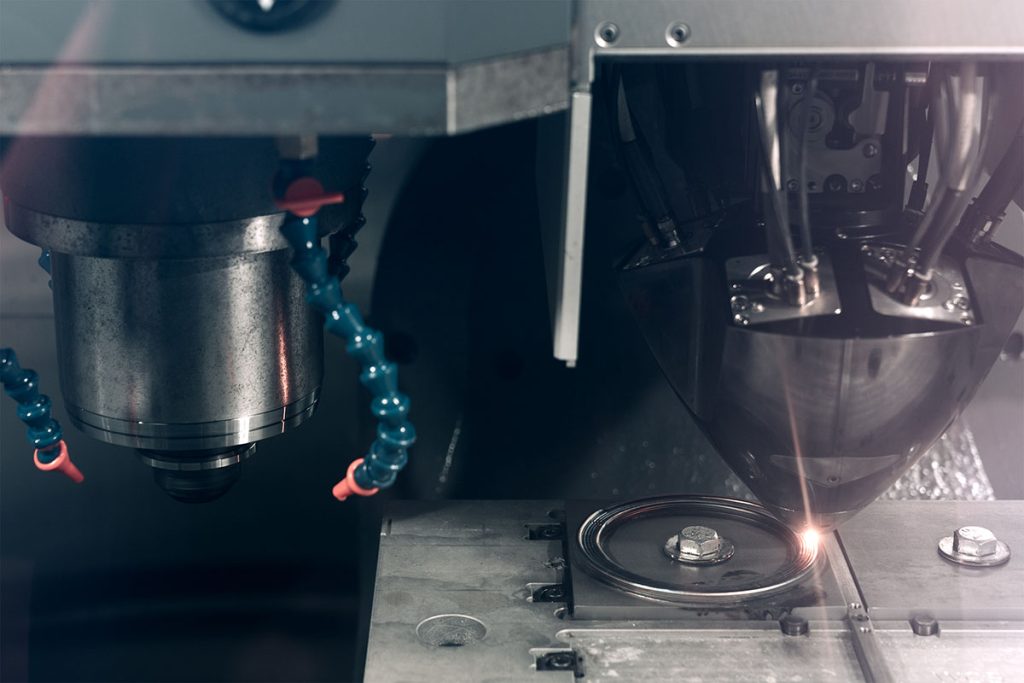 The inside of a hybrid manufacturing system while the additive part is being used to weld what will become a bearing part. Also visible is the chuck that's used for the subtractive processes.